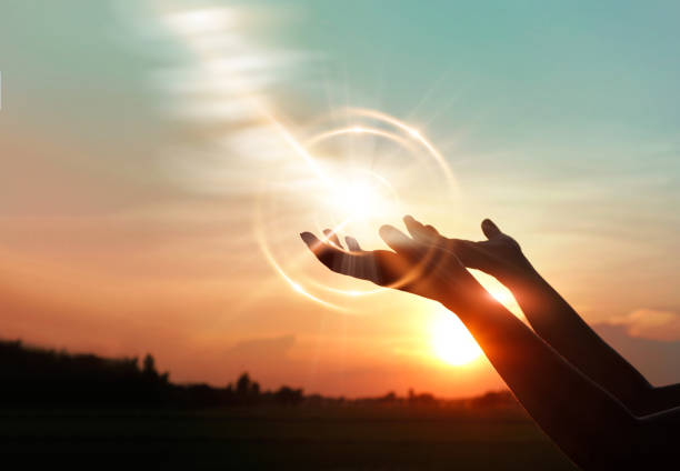 Woman hands praying for blessing from god on sunset background - Holy  Spirit Church